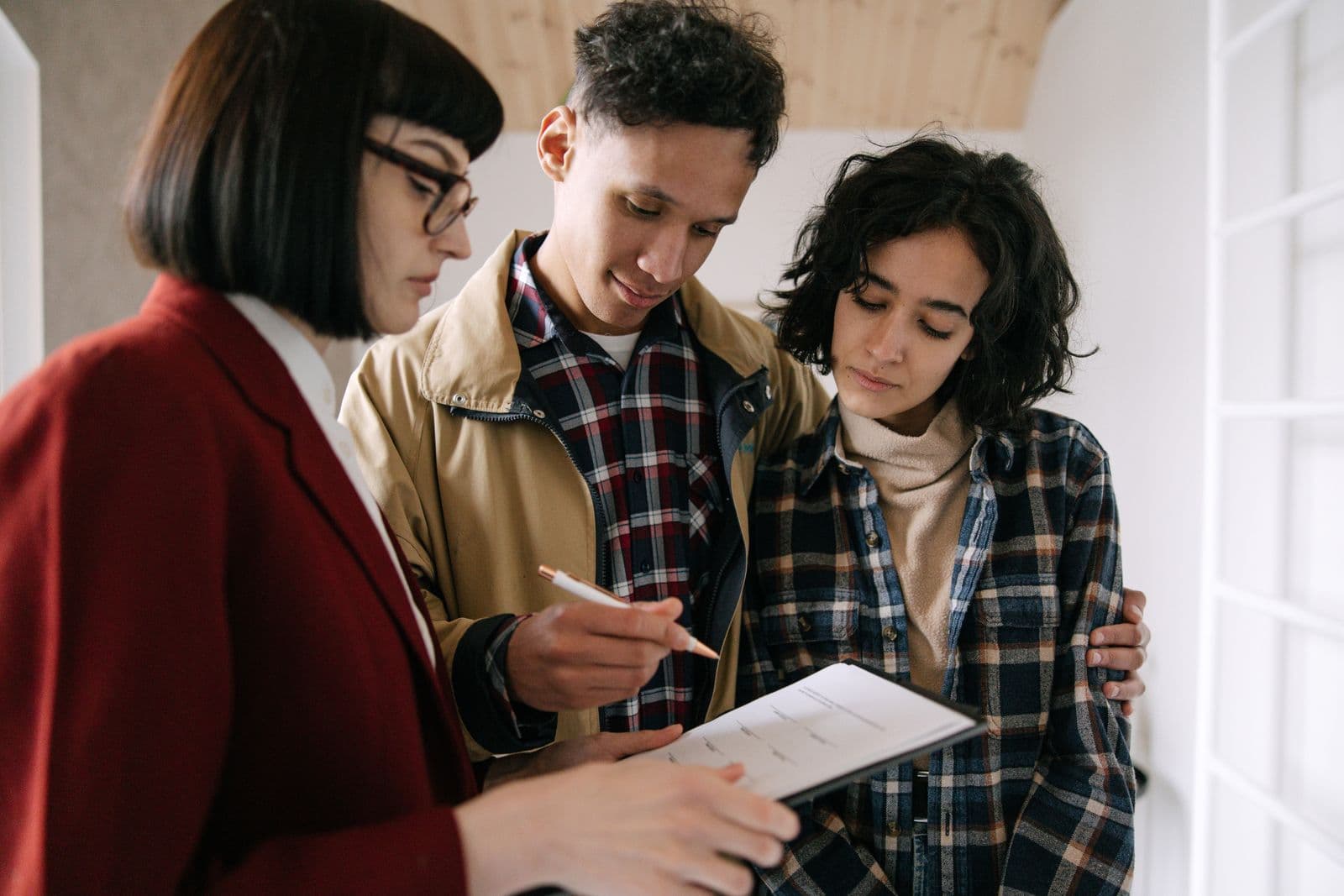 Un couple examine un document avec une conseillère, lors d'un rendez-vous