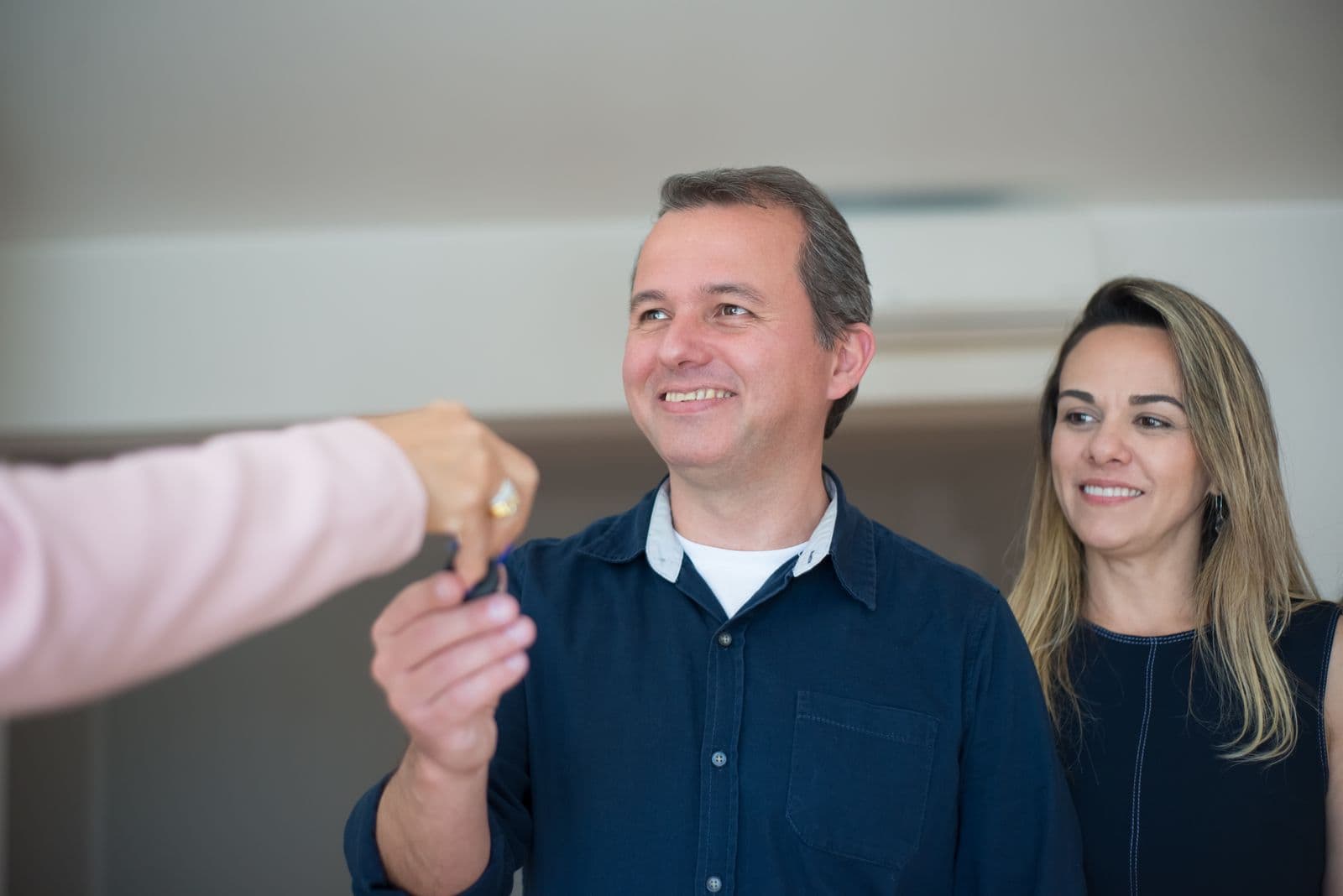 Un couple reçoit les clés de son logement, souriant